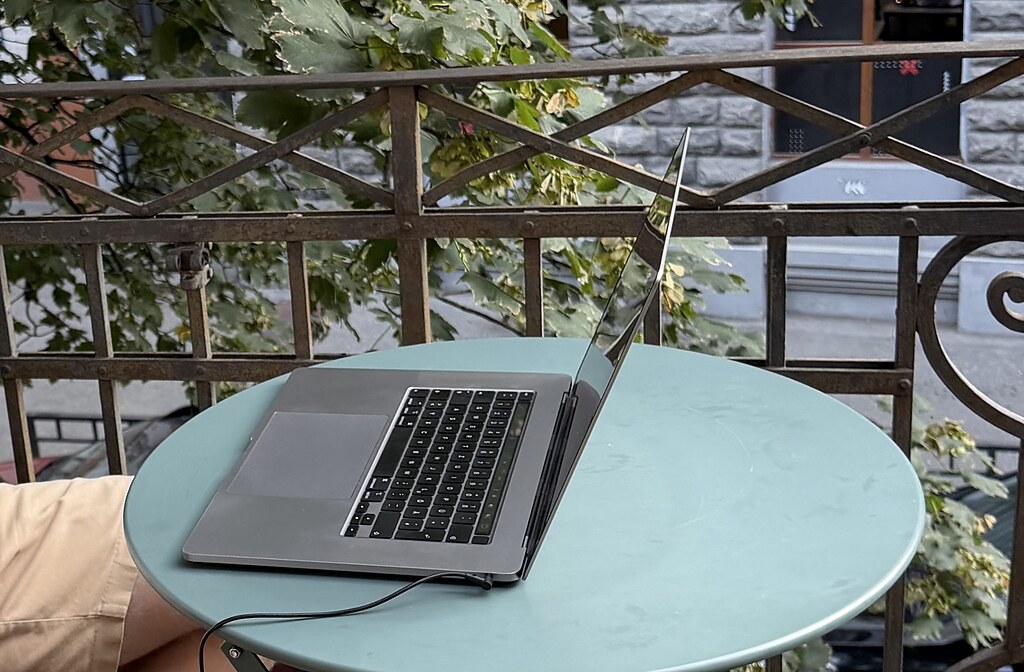 MacBook auf einem blauen Metall Tisch auf einem alten Balkon in Tiflis, Georgien