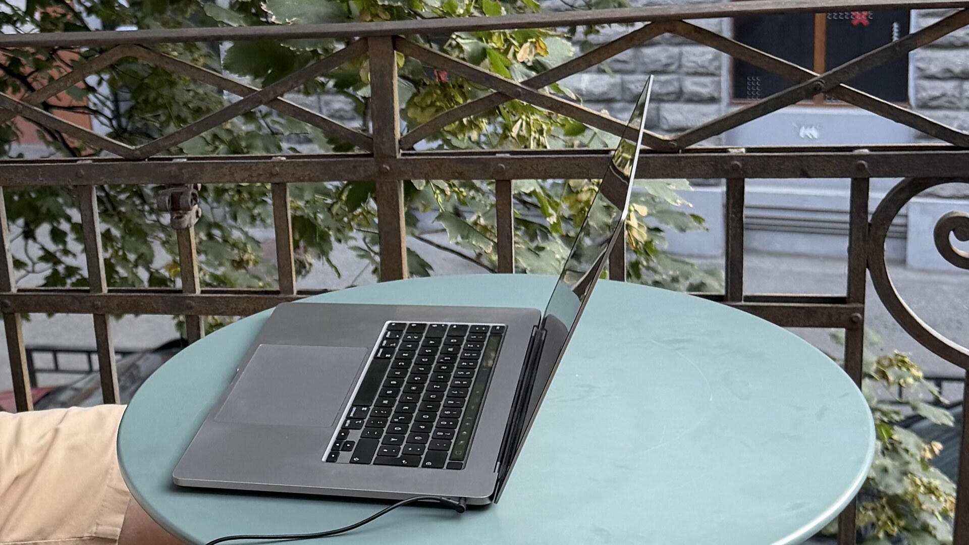 MacBook auf einem blauen Metall Tisch auf einem alten Balkon in Tiflis, Georgien