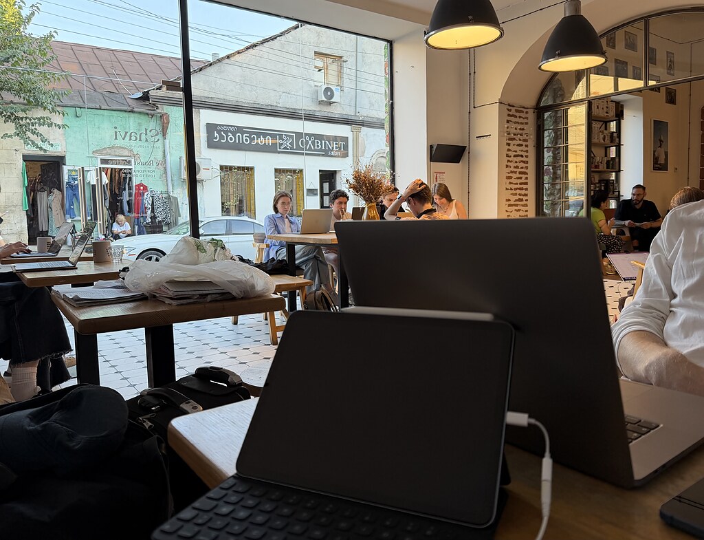 IPad und MacBook auf einem Holztisch in der Kaffee Rösterei Shavi Coffee Roasters in Tiflis in Georgien
