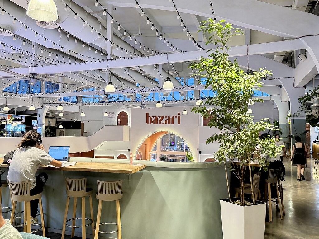 Bazari Orbeliani, Markthalle mit den Essensständen, hier sitzt einer mit Lasptop auf einem Hochstuhl und hört Musik