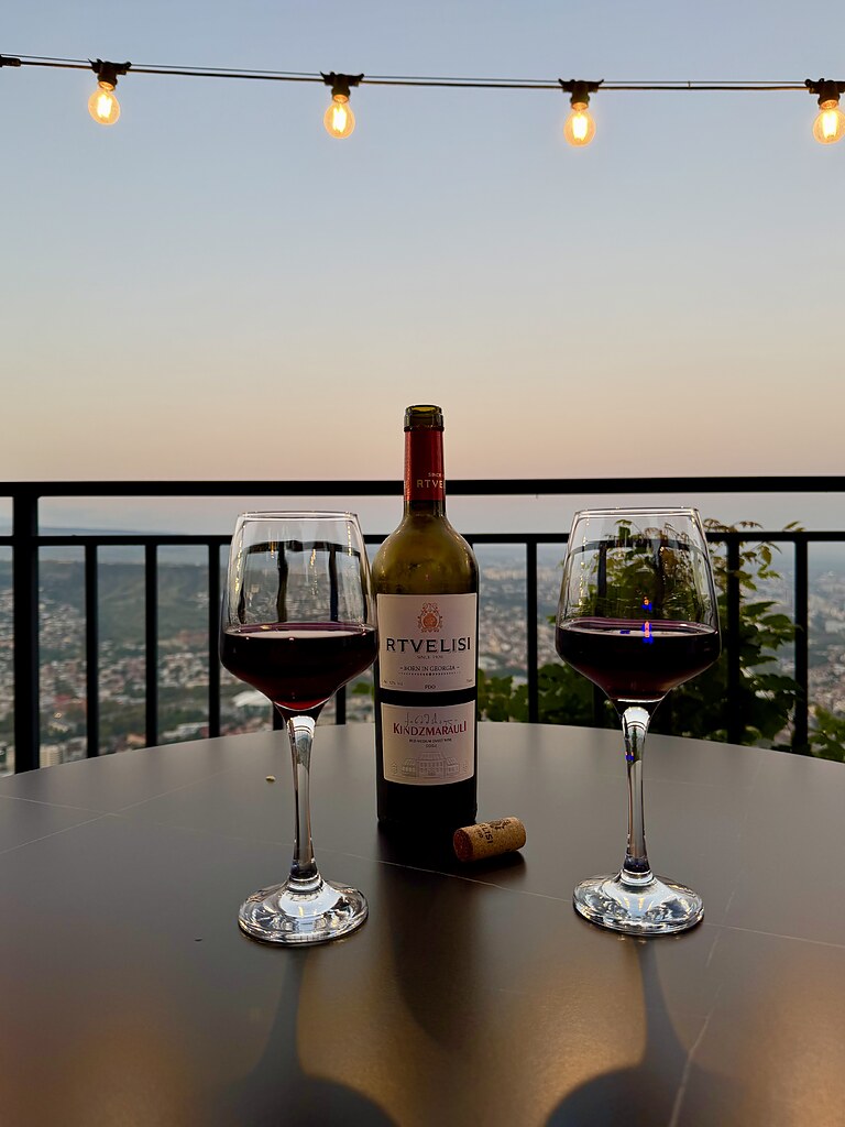 Wein, Lichterkette und Aussicht am Abend im Mtatsminda Freizeitpark Tiflis