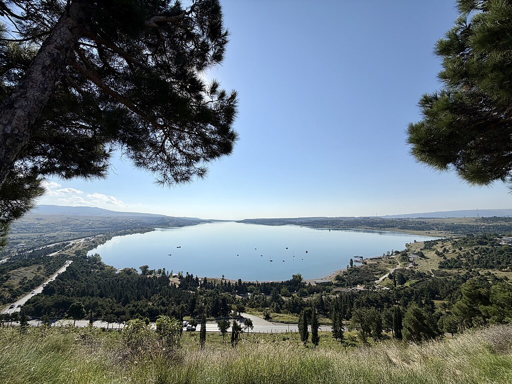 Tiflis Sea im Tal, rund herum grüne Bäume, eine Wiese und eine Straße
