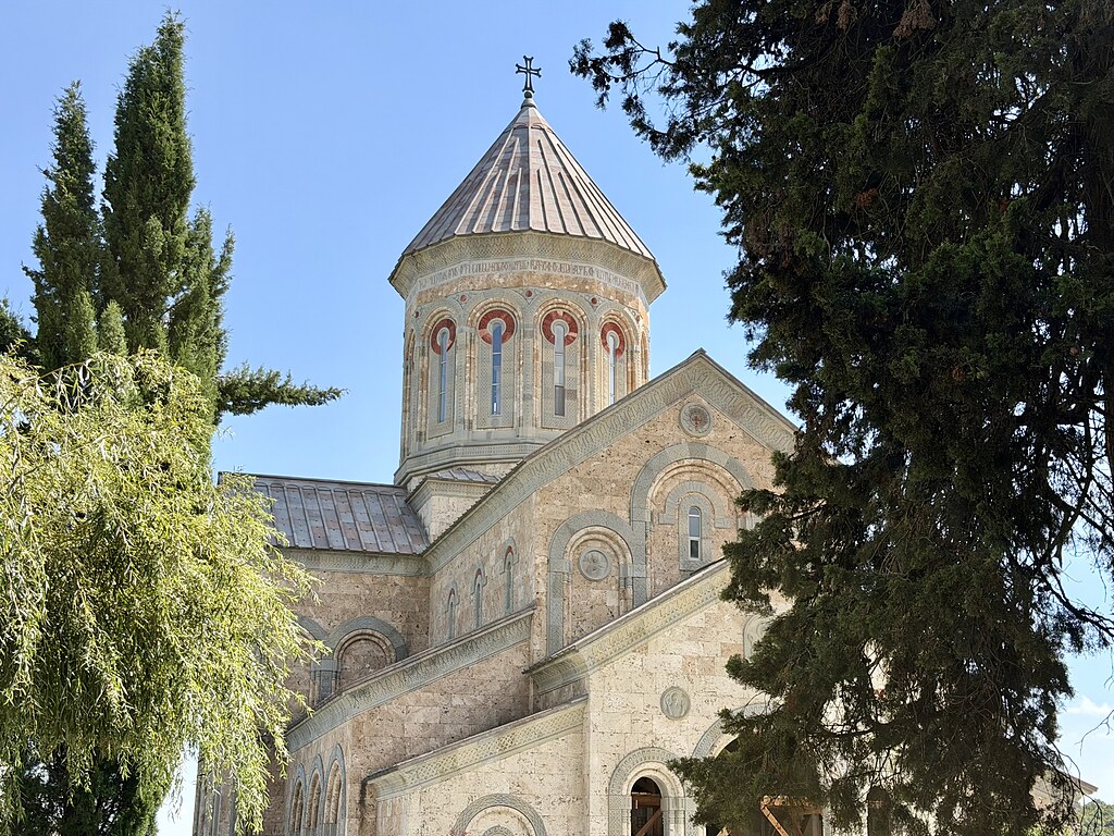 Frauenkloster Bodbe umgeben von grünen Bäumen und blauem Himmel