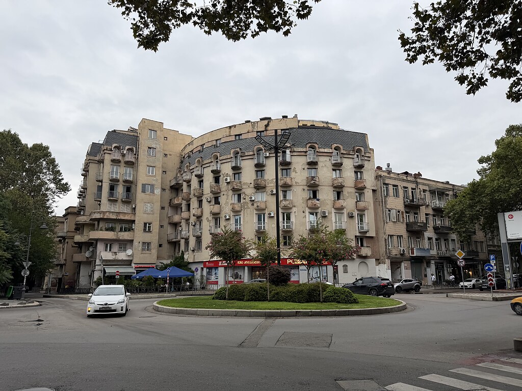 Altes, heruntergekommenes, bewohntes sowjetisches Gebäude am Kreisverkehr in Tiflis