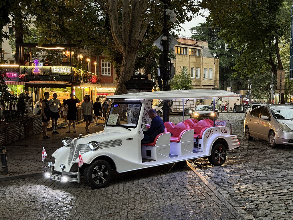 Passnoramibus in der Altstadt von Tiflis, Georgien. Der Fahrer wartet auf seine nächsten Kunden für die Stadtrundfahrt oder City-Tour