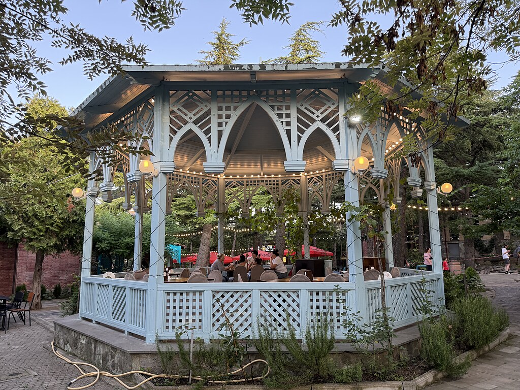 Blauer, mit Lichterketten beleuchteter Holz Pavillon zum essen im Park