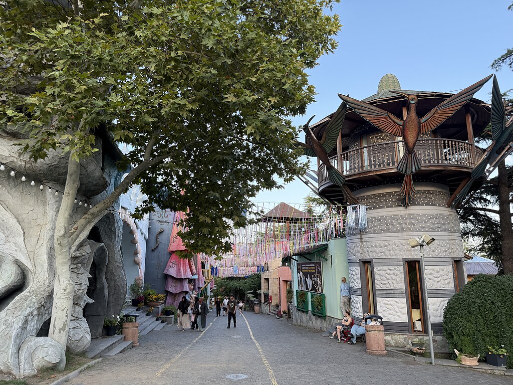 Mtatsminda Freizeitpark Tiflis, bunte Fähnchen in der Straße, Holz Vogel am Gebäude