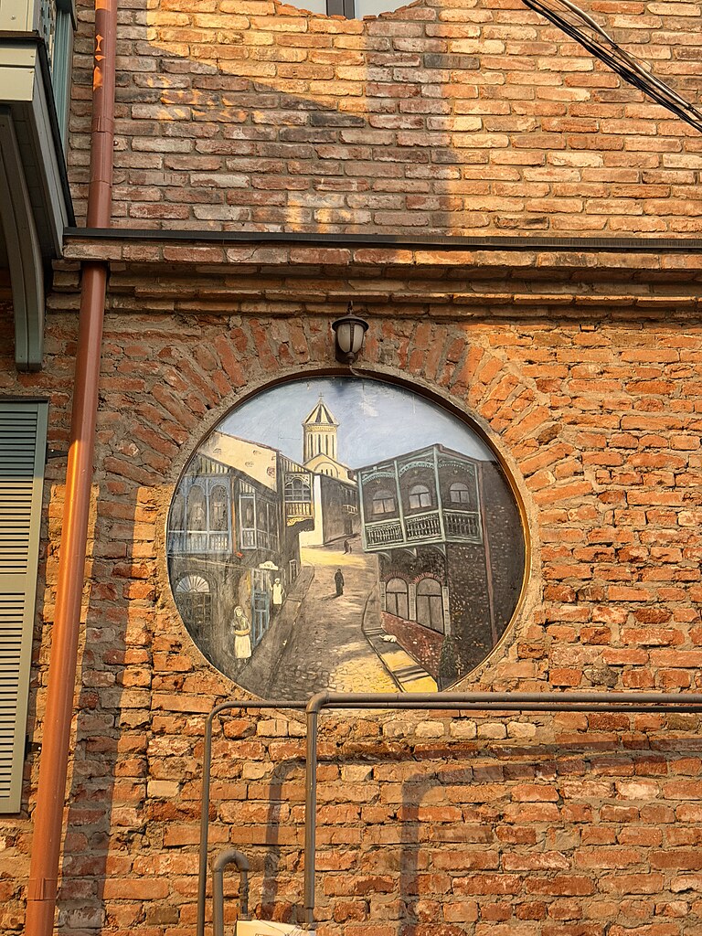 Gemälde an einer Hauswand in Tiflis mit dem Bild von der Sameba-Kathedrale und Häuser Fassaden