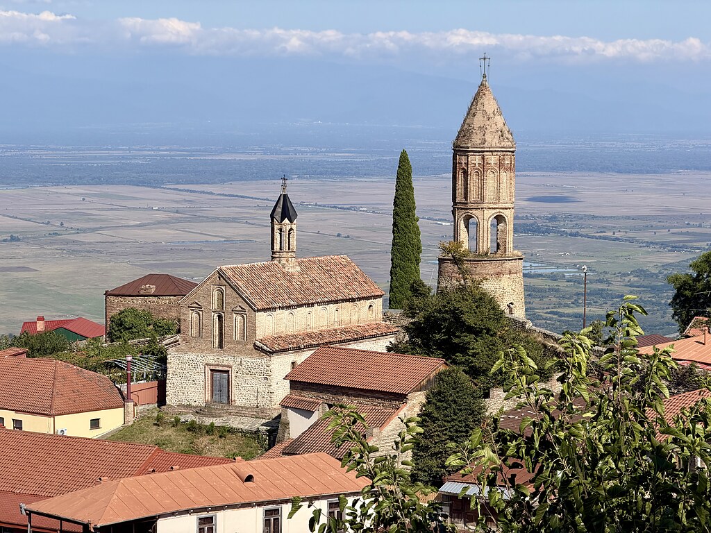Aussicht auf eine Kirche und Häuser in Sighnaghi auf dem Berg, der Toskana Georgiens