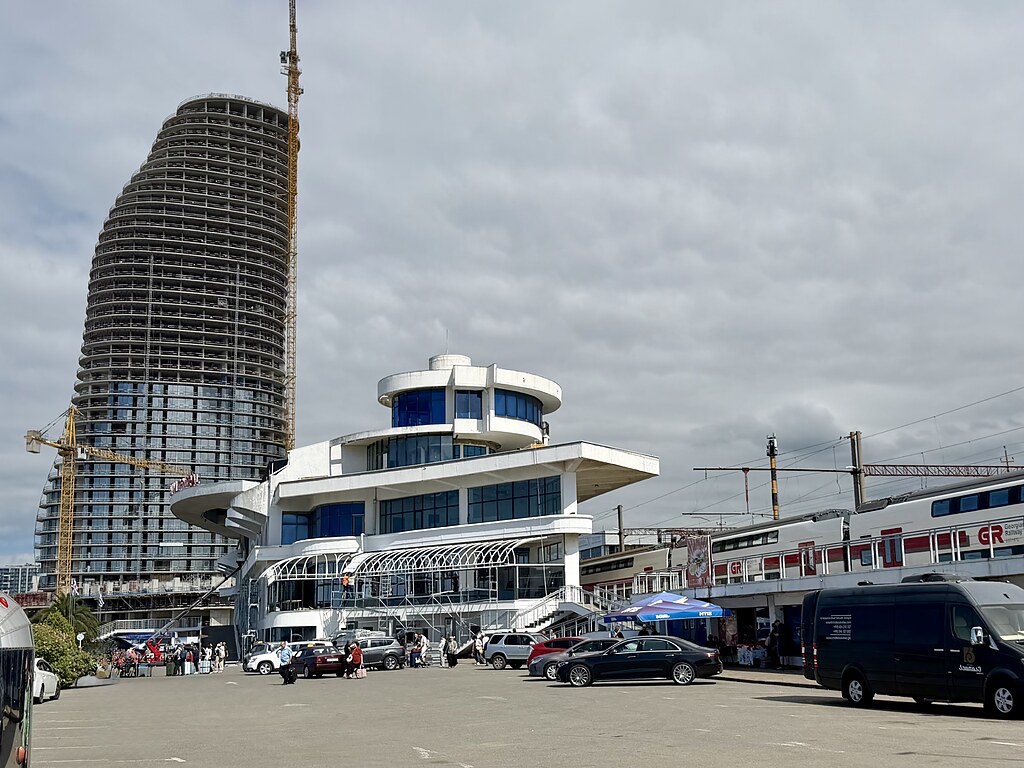 Bahnhof Batumi mit Parkplatz, Bahnsteigen und Zügen der Georgian Railway.