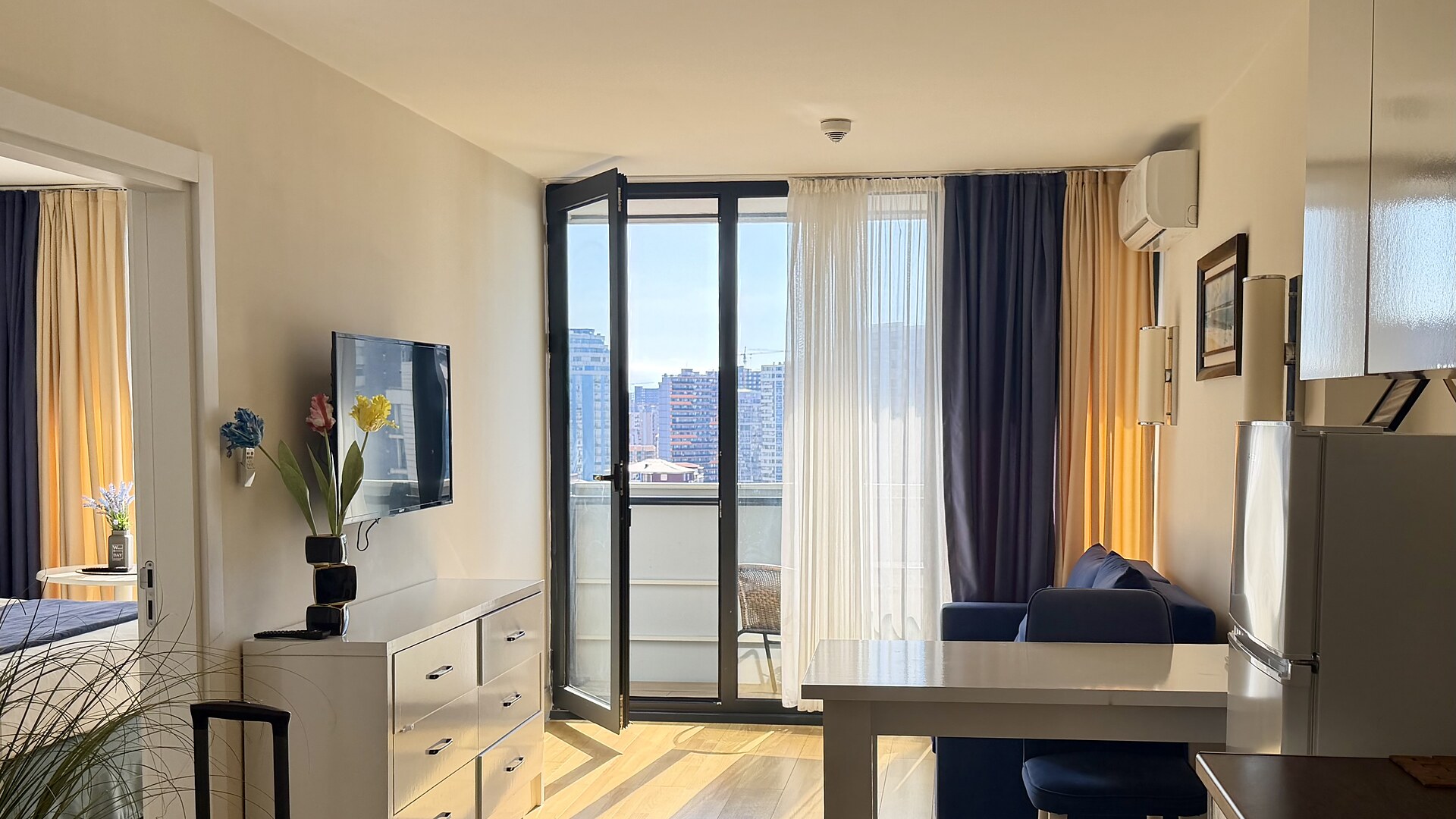 Wohnzimmer einer Ferienwohnung in Batumi mit Tür zum Balkon und Blick aufs Meer