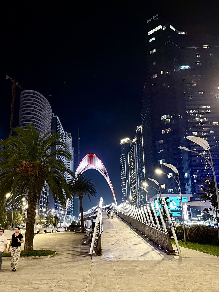 Black Sea Arch beleuchtet zwischen Hochhäusern in Batumi, Georgien.